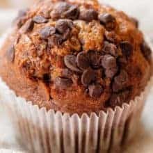 close up of Ultimate Chocolate Chip Pumpkin Muffin in a white cupcake liner