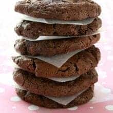 stack of White Chocolate Cocoa Cookies with parchment paper in between each piece