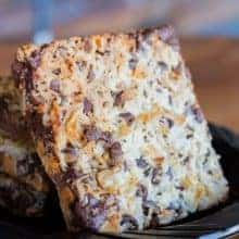 close up slice of Seven layer bars loaded with pecans, chocolate chips and shredded coconut