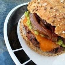 a plate with Homemade Burger patty in a burger bun with sesame seeds