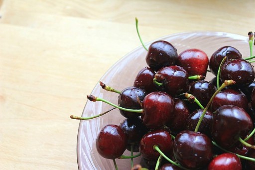 a bowl of red fresh cherries