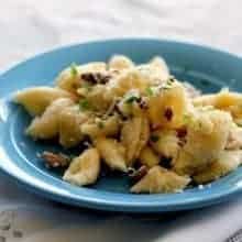 Baked Cheesy Bacon & Chanterelle Pasta in a blue plate over white cloth