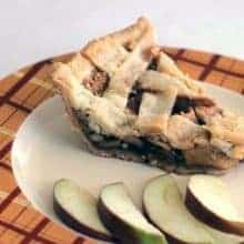 Slice of Homemade Sweet Apple Pie with slices of apple in an orange printed plate