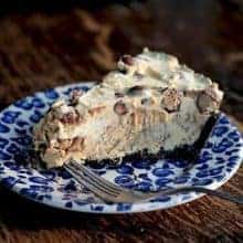 Close up Slice of Ice Cream Peanut Butter Pie in a blue dessert plate on wood background