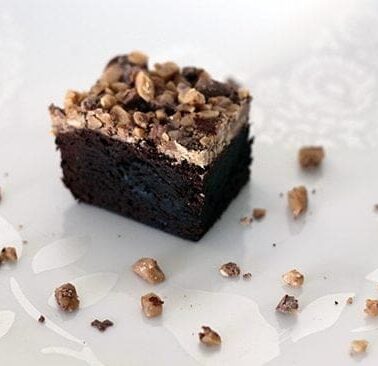 top down shot of fudgy Brownies topped with toffee crunch on white background