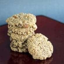 stack of School Lunch Holy Crap Cookies on maroon table with light blue background