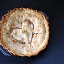 Peaches & Cream Pie in a pie dish with heart shape on top crust