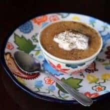 a bowl of Pumpkin Soup topped with whipping cream, sprinkled with pepper and salt