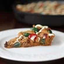 a slice of Christmas Fruitcake Chocolate Chip Skillet Cookie in a white dessert plate