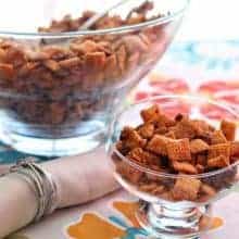 Bacon & Brown Sugar Chex Mix in a large transparent bowl with spoon and in transparent cup