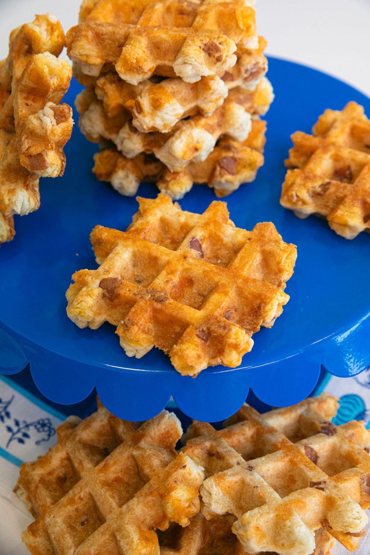 bacon and cheddar waffle biscuits in stacks on a blue platter