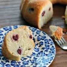 Blackberry Coconut Bundt Cake in front of blue printed plate with a slice of it