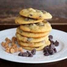 Stack of Peanut Butter and Chocolate Banana Pudding Cookies in white plate with chocolate chips