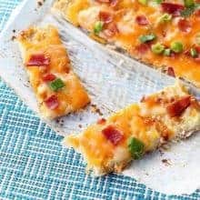 close up of Fully Loaded Cauliflower Garlic Bread on parchment paper