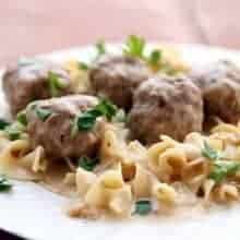 Close up Turkey Swedish Meatballs served over egg noodles garnished with parsley leaves