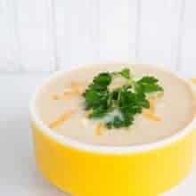 Cream of Chicken and Cauliflower Soup Topped with Shredded Cheese and Parsley