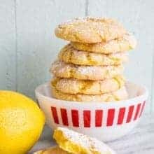 White printed bowl with stack of Cake Mix Cookies sprinkled with powdered sugar