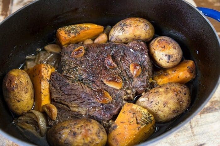 Pot roast with beef broth and red wine in a Dutch oven