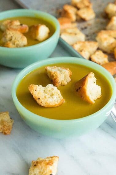 close up bowls of Vegan Curried Split Pea Soup topped with Homemade Garlic Croutons