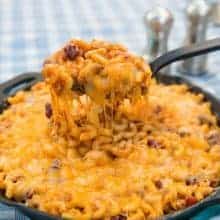 close up of a spoon full of cheesy chili mac skillet