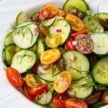 Cucumber Salad with Tomato and Dill in a large white serving bowl