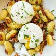 top down shot of Gnocchi Breakfast Skillet with bacon, green onions and top with eggs