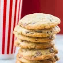 Close up Stack of DoubleTree Hotel Chocolate Chip Cookies, tall stripe red tumbler at the back