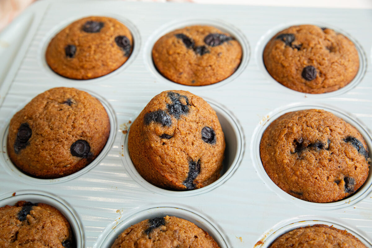 nine grain blueberry muffins in a muffin tin