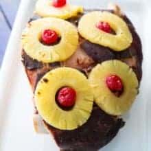 close up Slow Cooker Ham on a vintage Corelle Serving Platter with pineapple rings and cherries on top