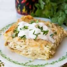 Close up Cheesy Green Chile Chicken Lasagna topped with sour cream and cilantro