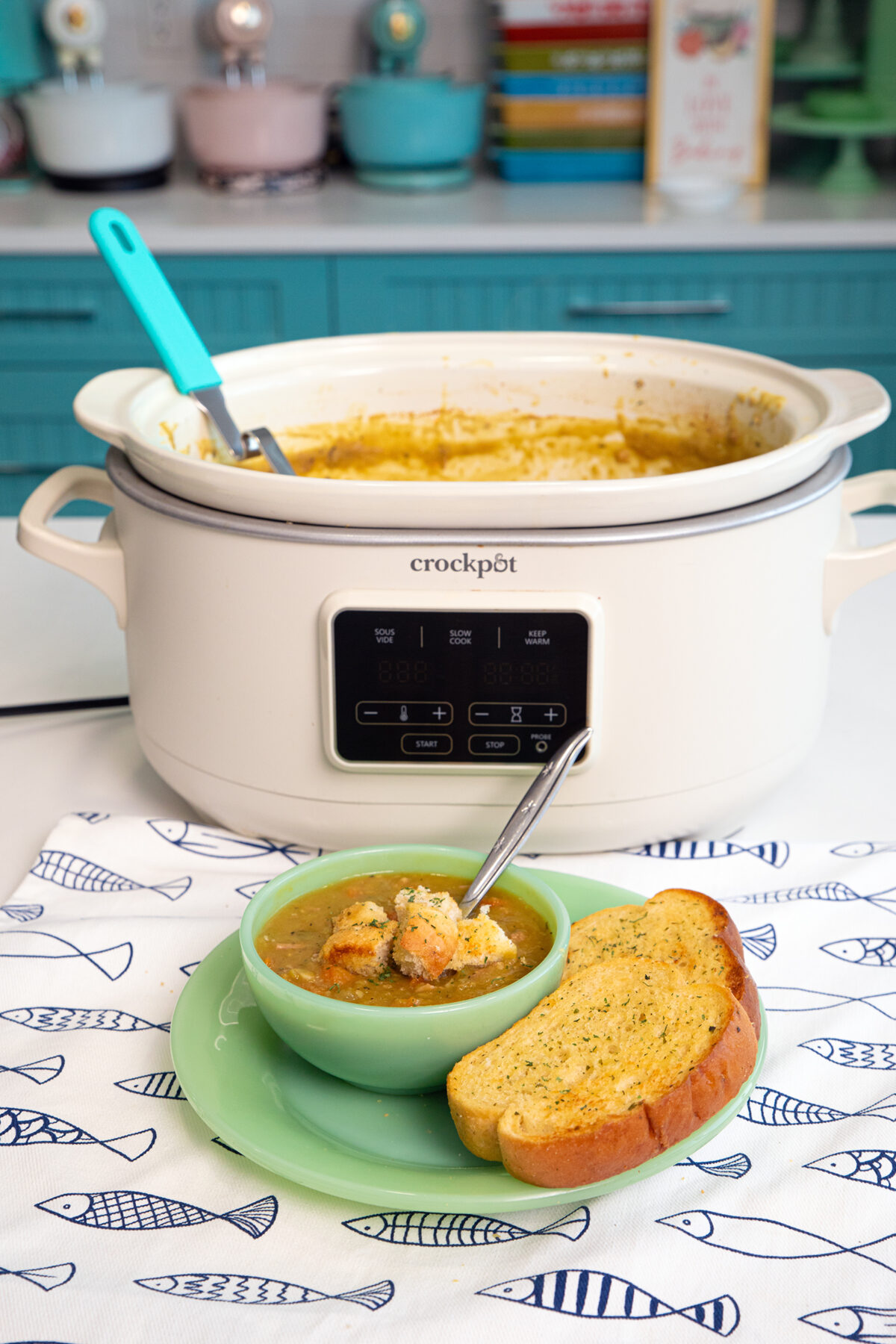 a white slow cooker with split pea soup in it