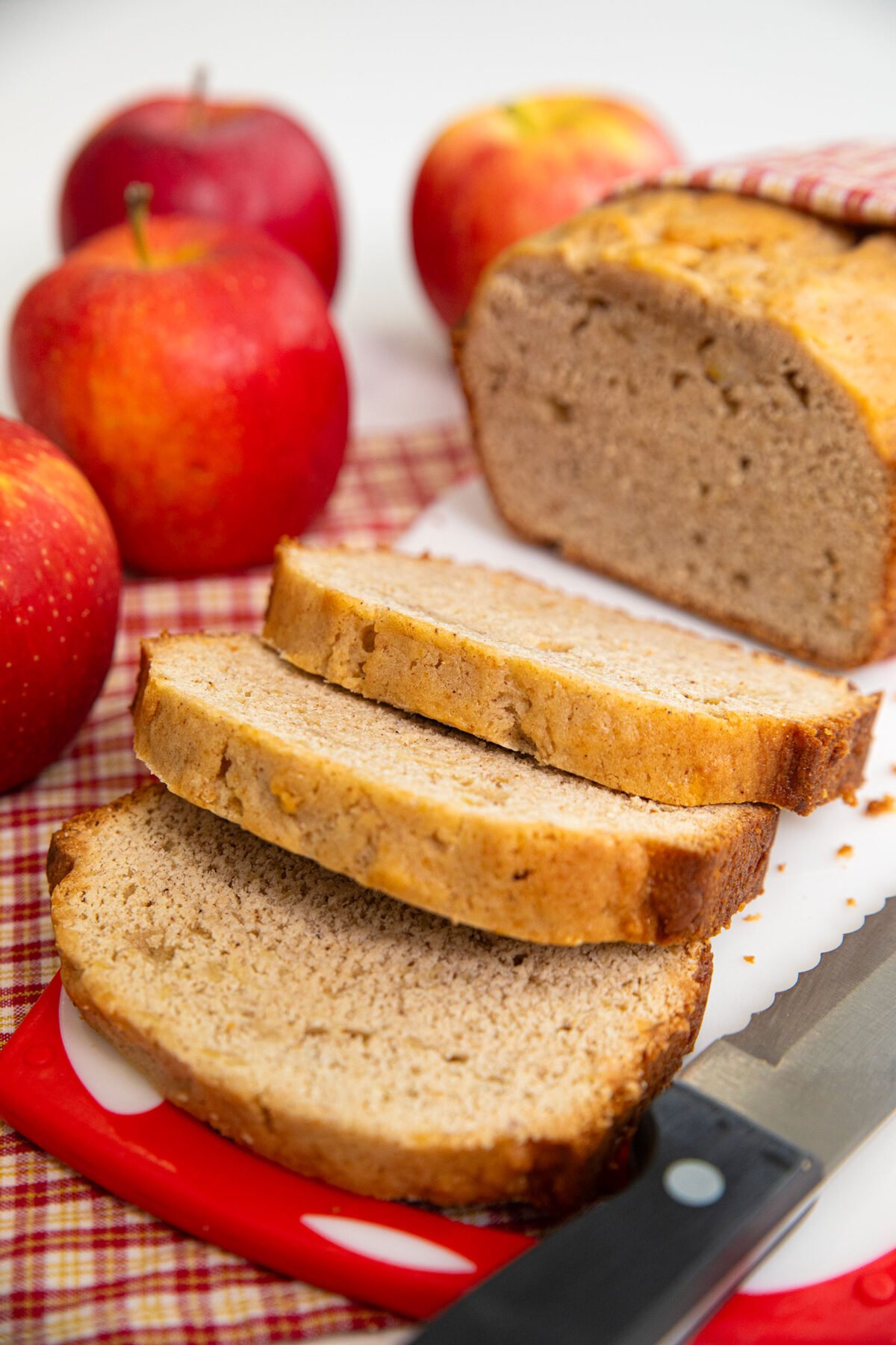 Sliced cinnamon apple loaf with apples on the side