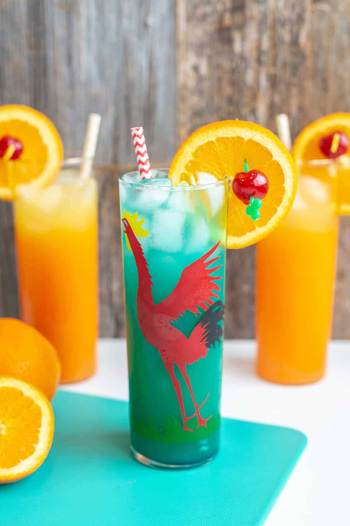 Summer cocktail in glass with orange slice and drinking straw