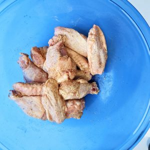 Chicken wings in a bowl covered in spice.