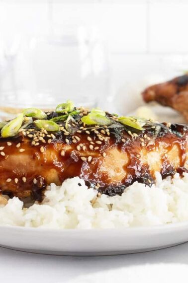 Grilled teriyaki chicken on a white plate with rice