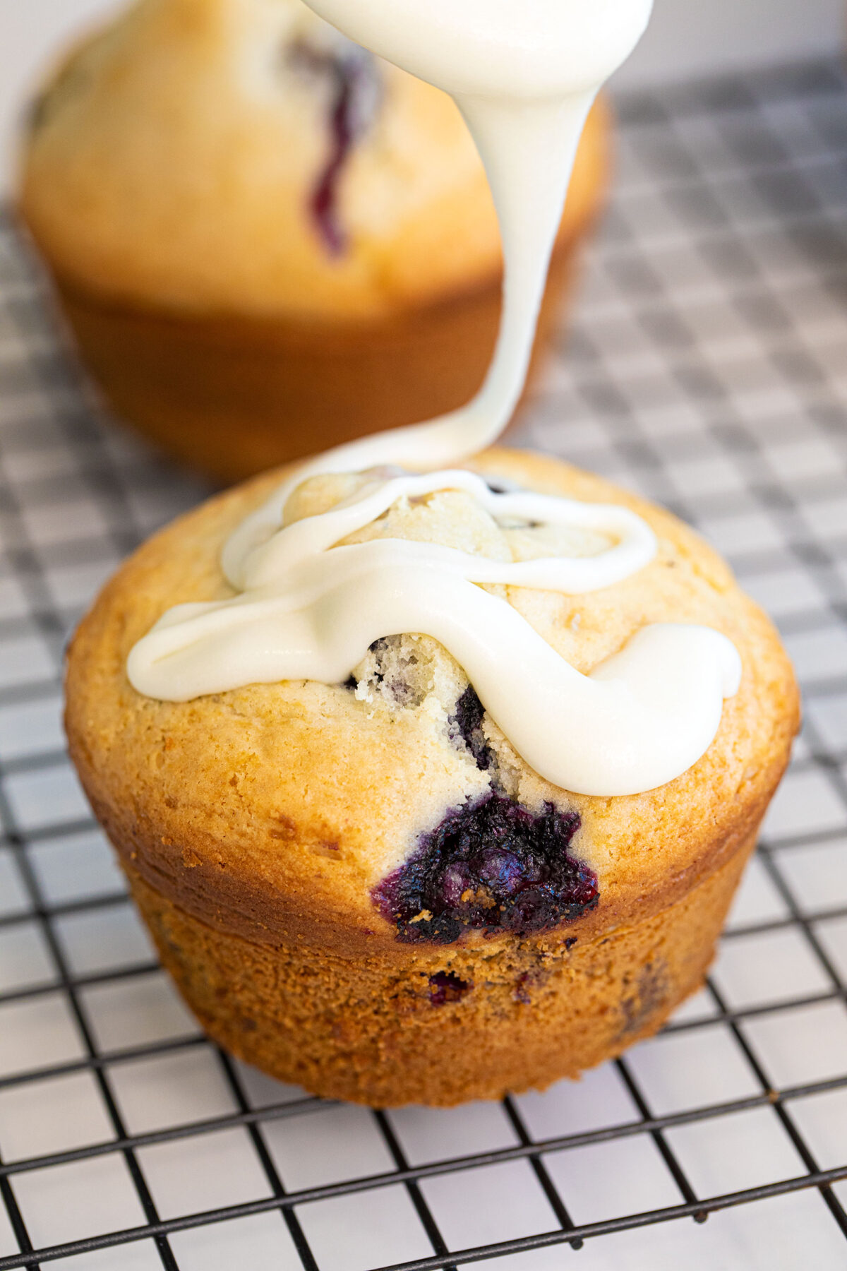 Bisquick blueberry muffins with icing glaze being drizzled on top