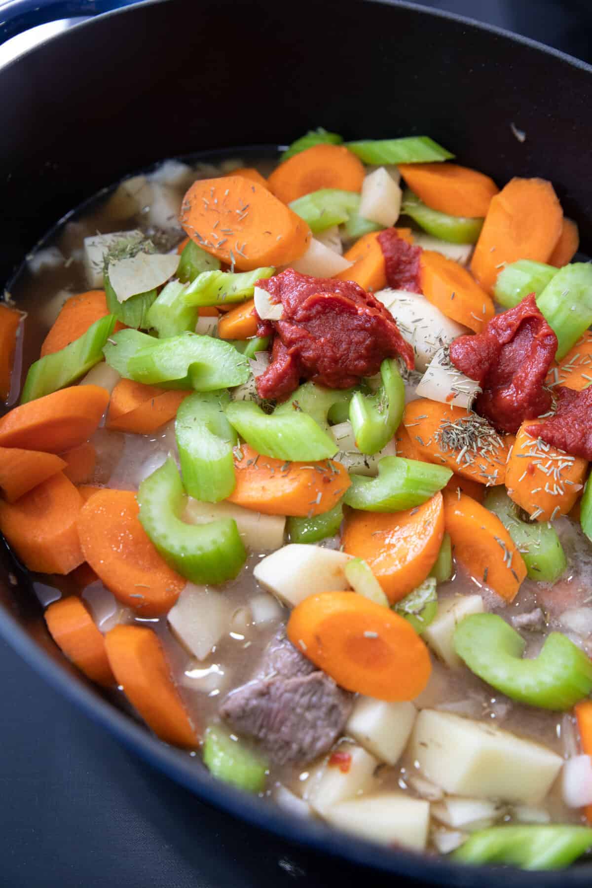 raw veggies and tomato sauce in a dutch oven