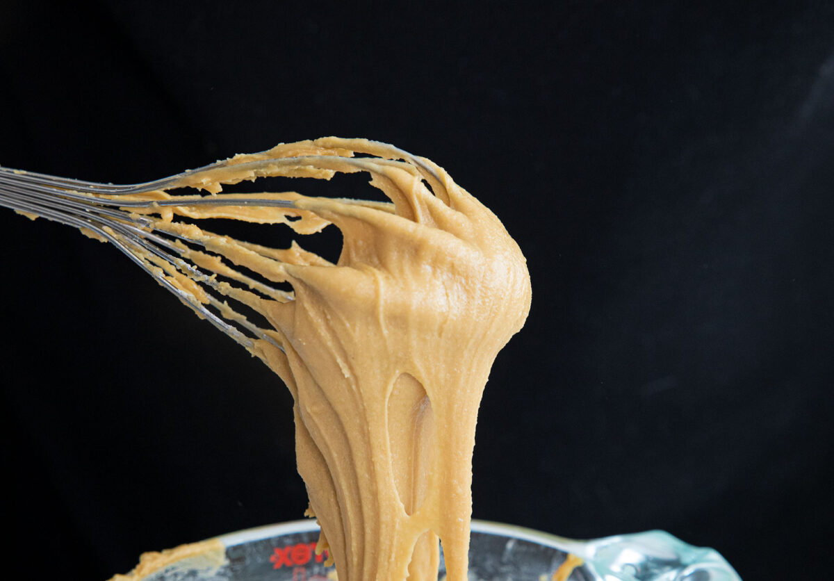 brown sugar icing glaze on a whisk