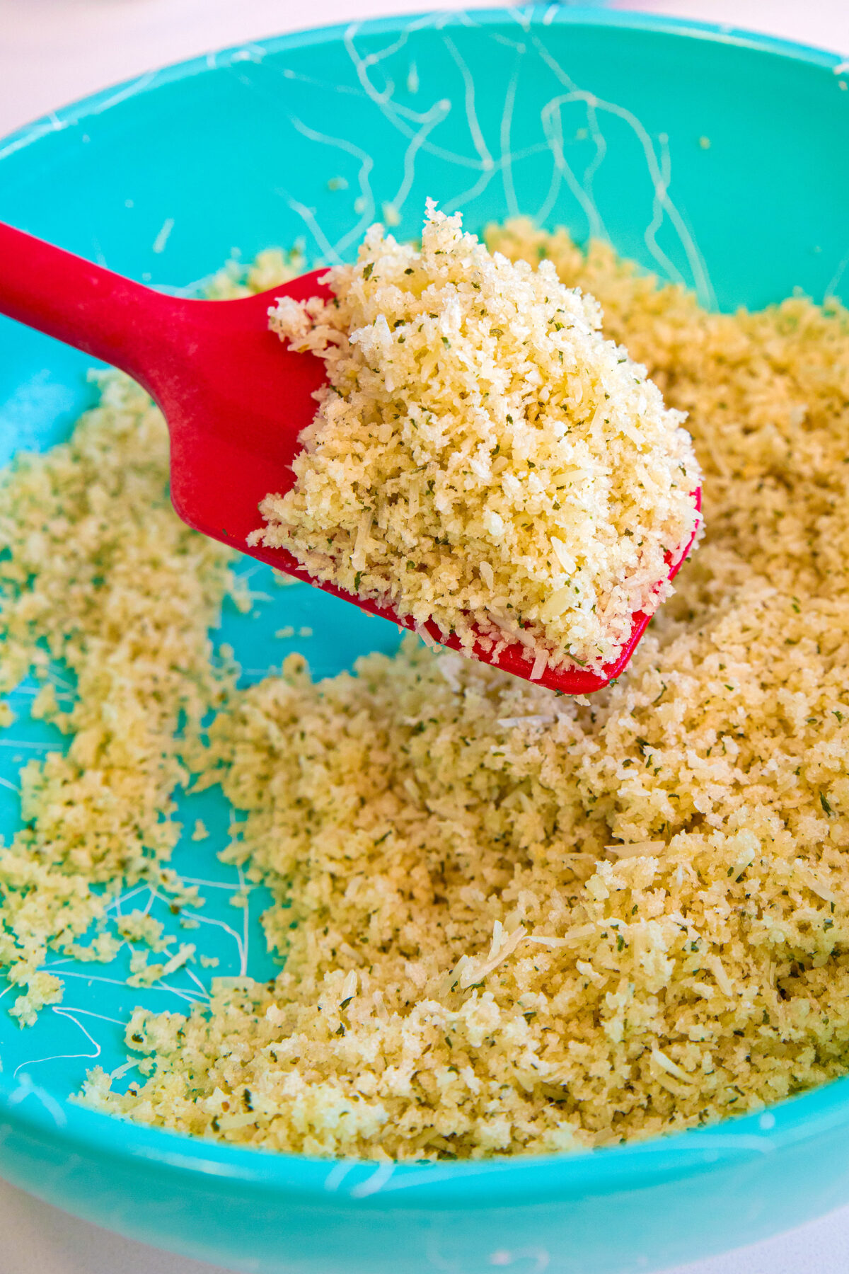 a red spoon full of panko breadcrumb topping