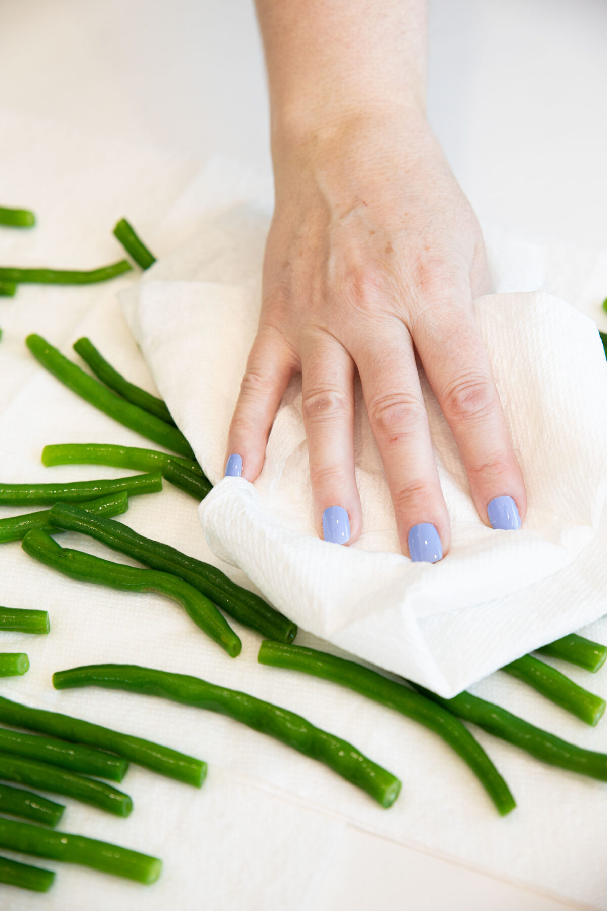 patting green beans dry with a paper towel