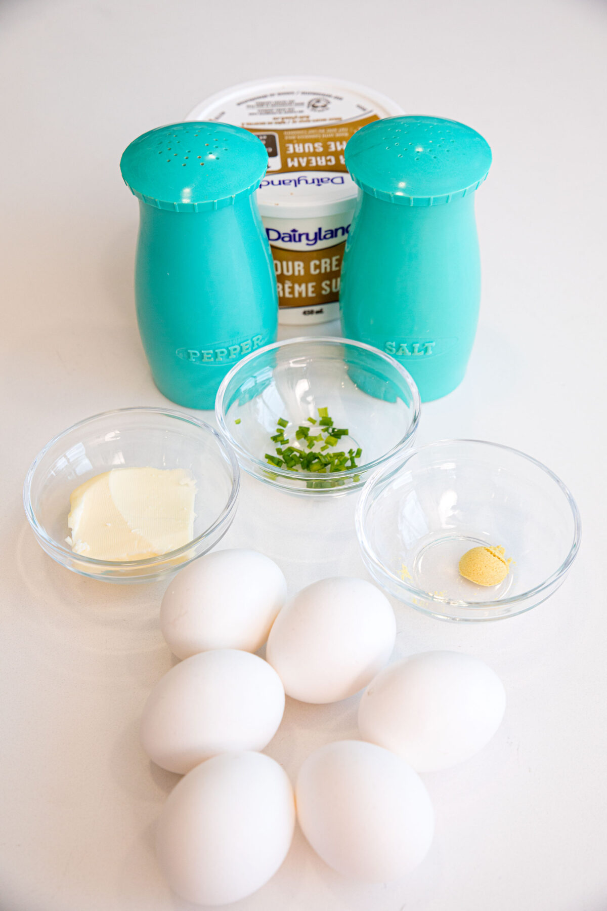 ingredients for sour cream scrambled eggs on a white counter