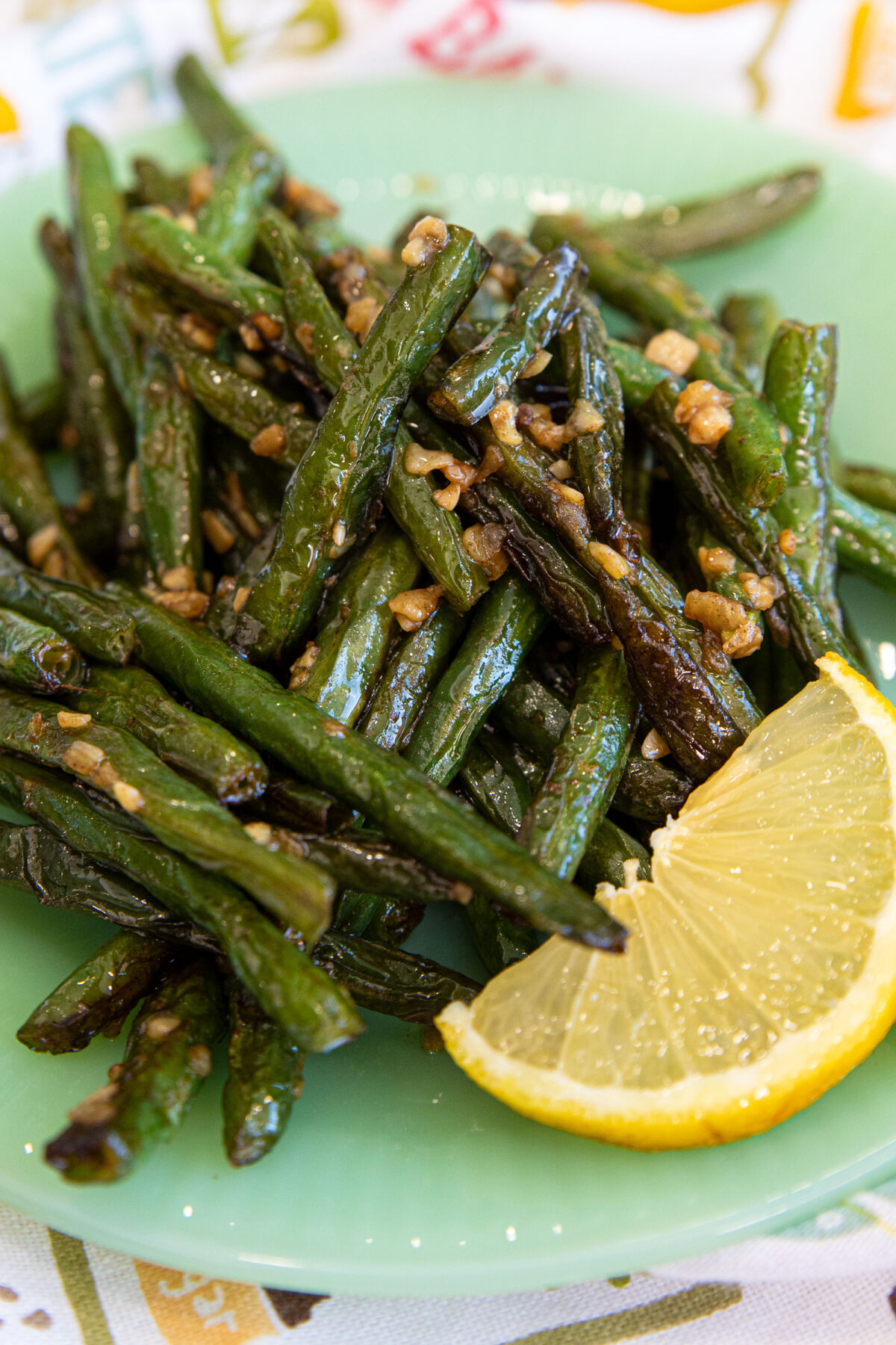 sauteed green beans on a plate  with a slice of lemon