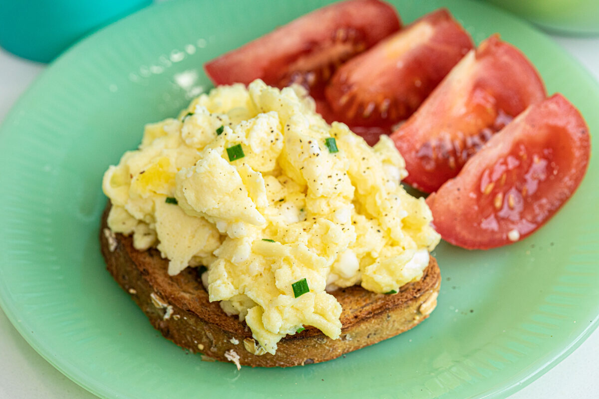 cottage cheese scrambled eggs on a plate with tomatoes