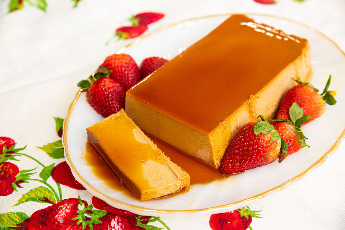 a flan on a white plate with sugar syrup on top
