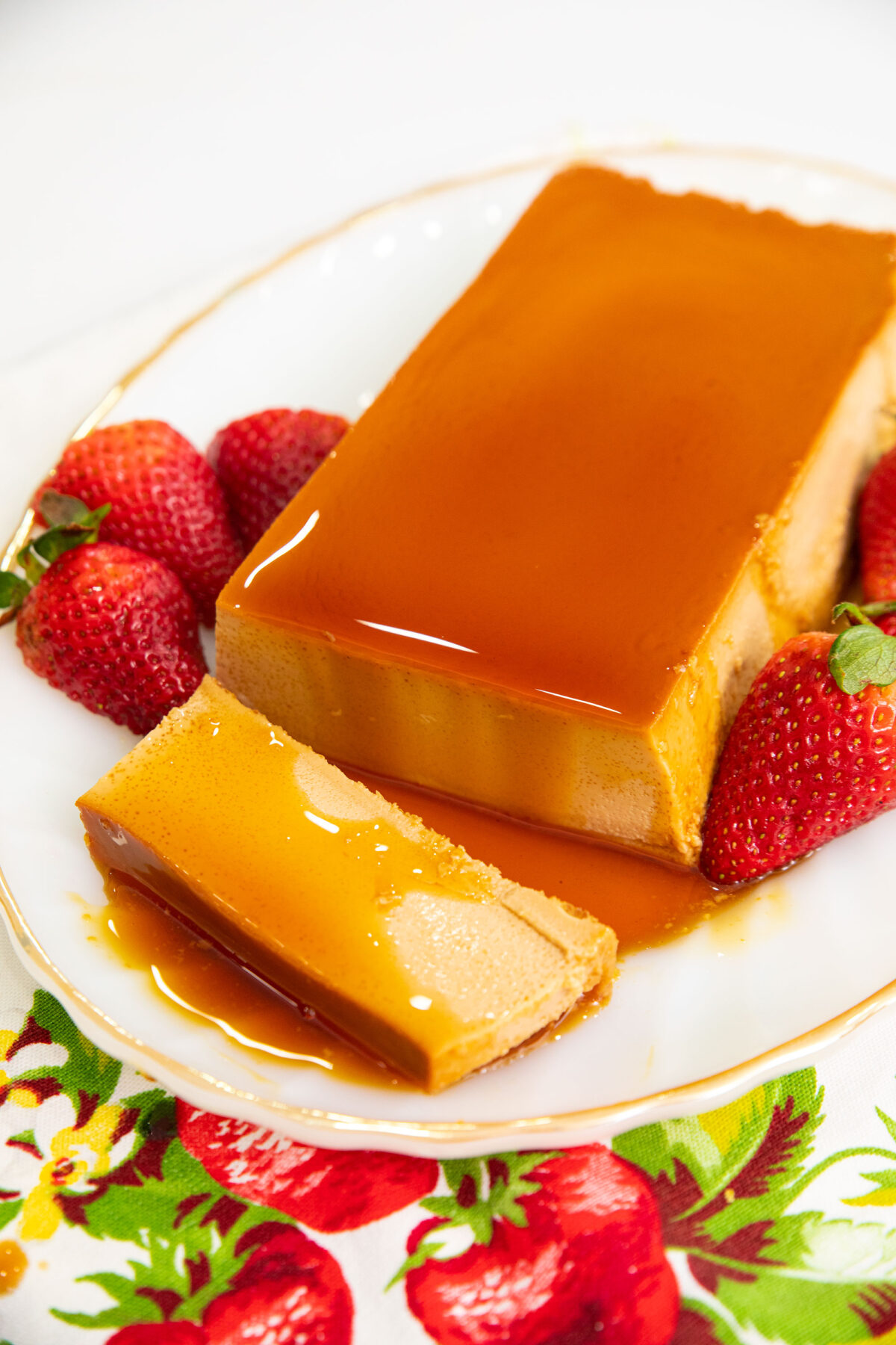 sliced flan on a white plate with strawberries