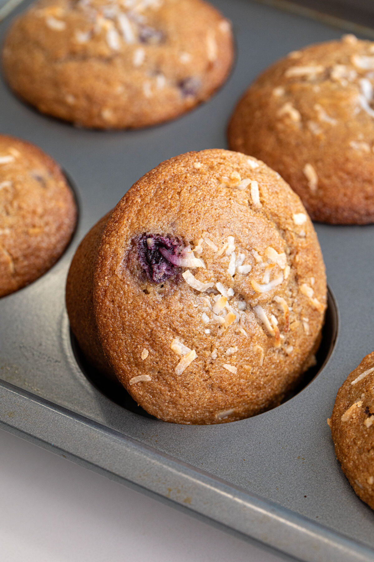 closeup of cherry coconut whole wheat muffins in a baking tin