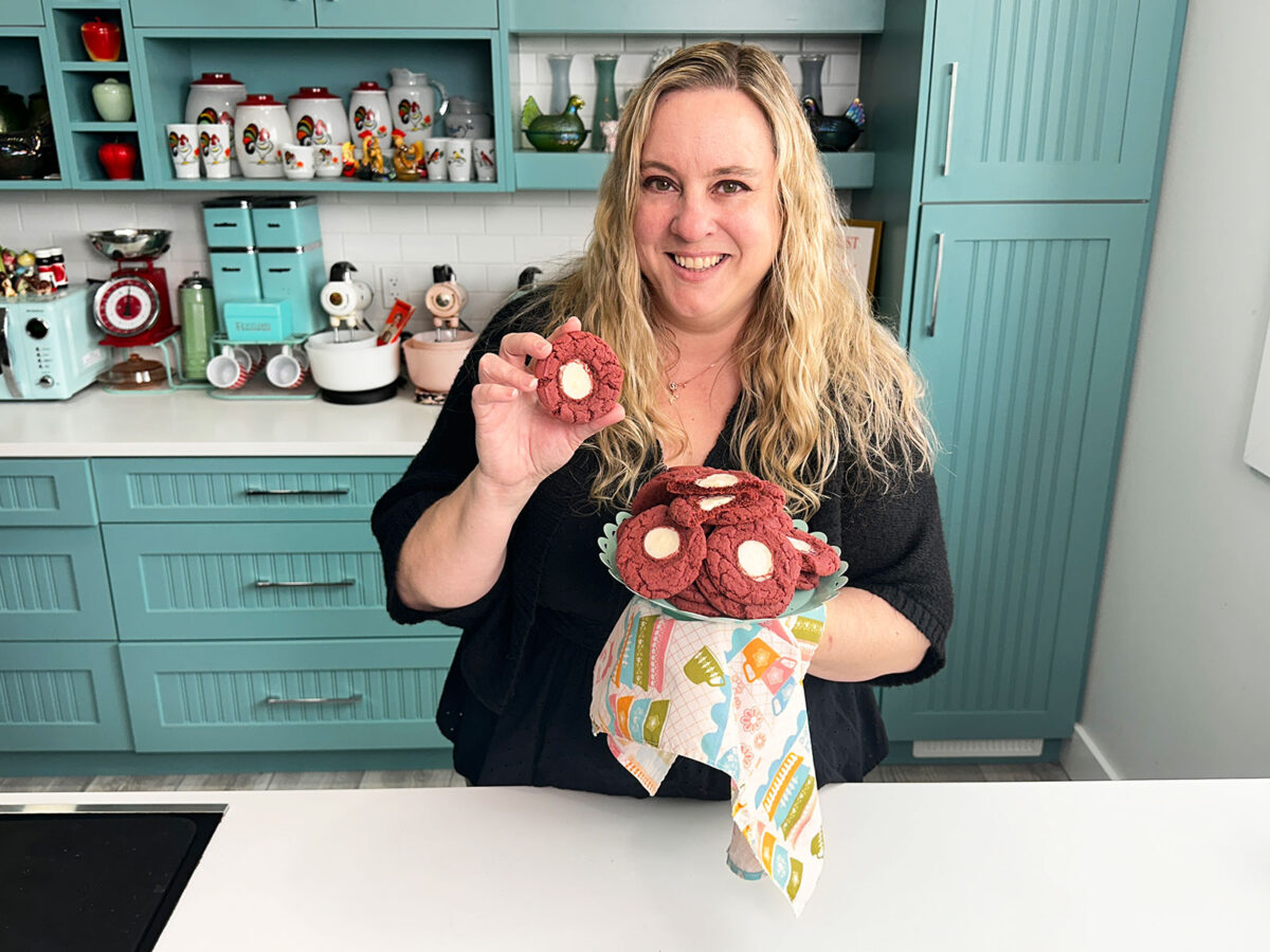 Red velvet cheesecake cookies being held by author karlynn on a plate and in her hand.