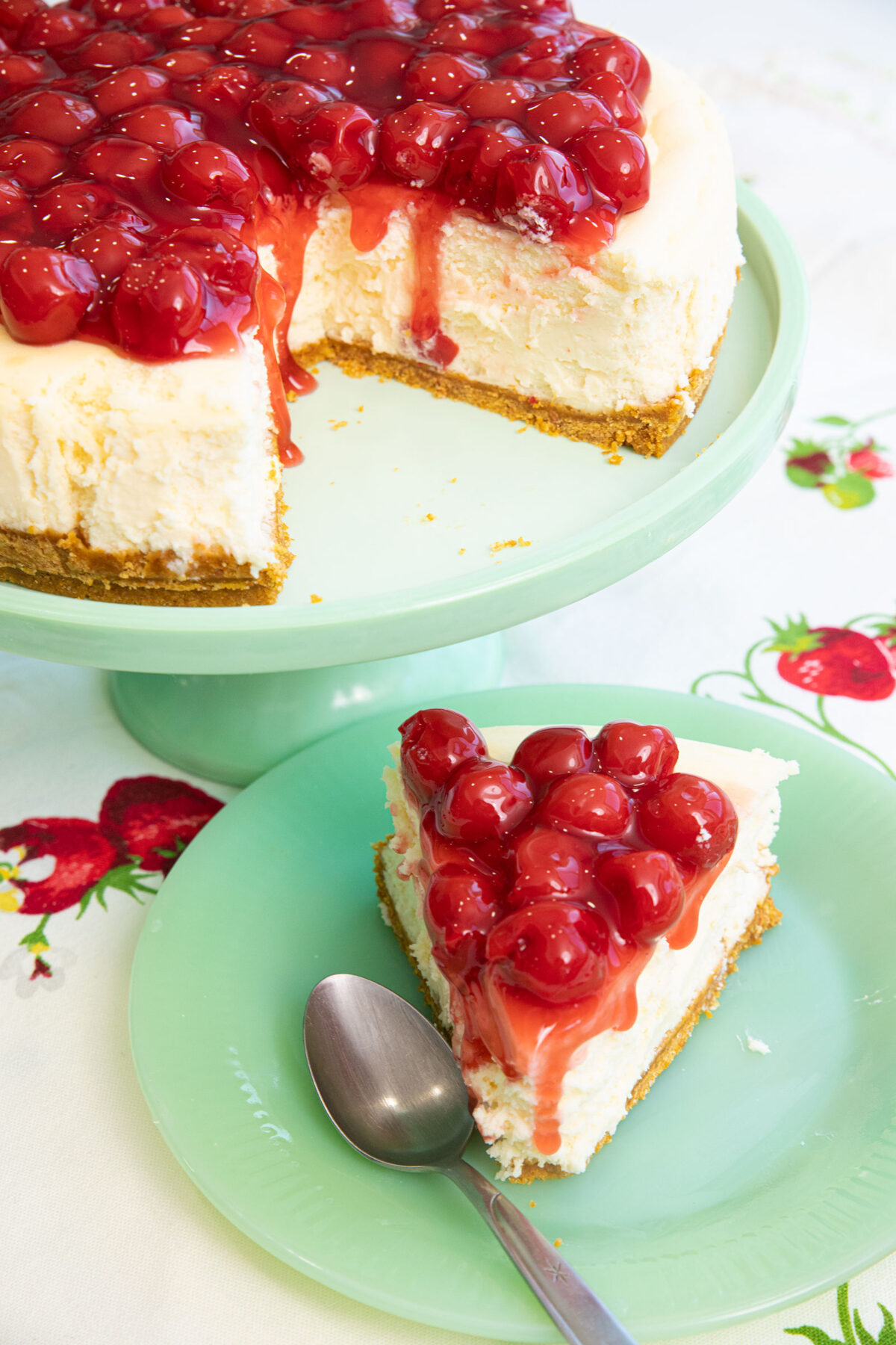 una porción de cheesecake de Philadelphia en un pequeño plato Jadeite con una cuchara