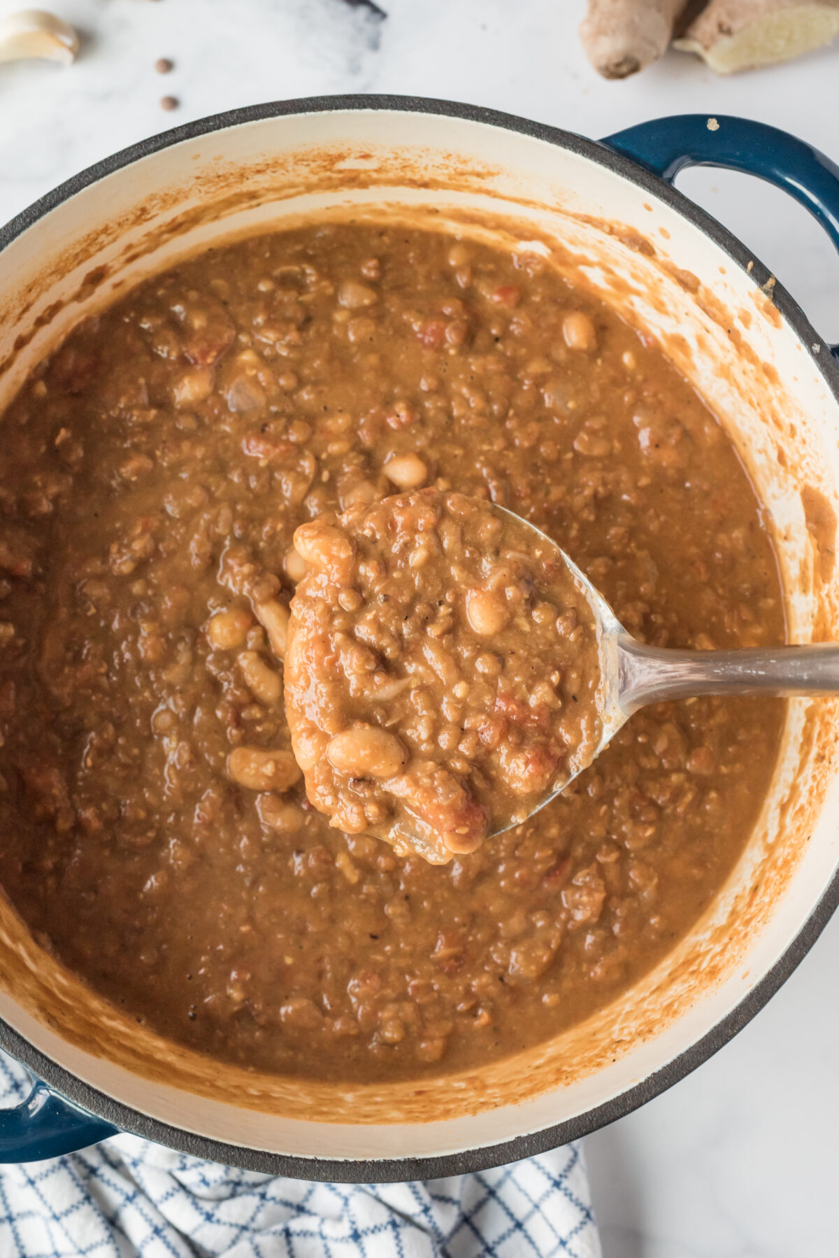 spicy bean and lentil soup in a pot with a ladle full of soup