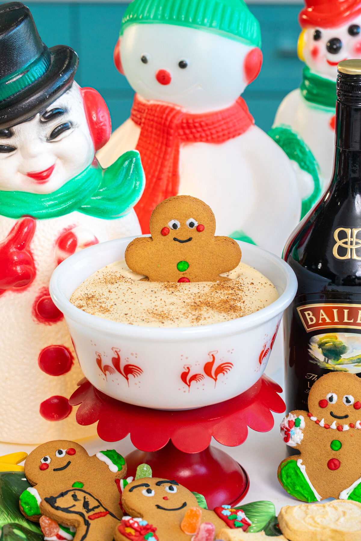 a large gingerbread cookie in a bowl of Baileys and eggnog dip